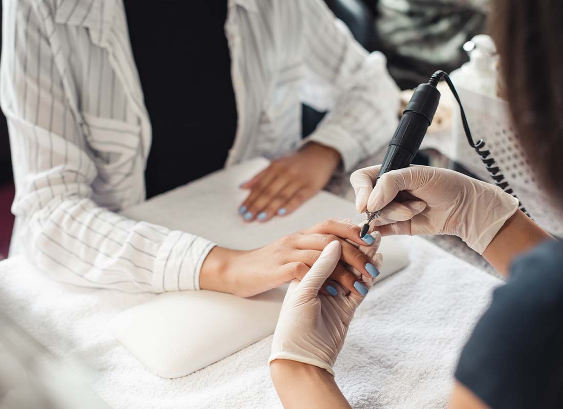 Nail Salon Insurance - Woman Getting Her Nails Done by a Beautician Manicurist in a Nail Salon